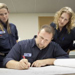 Two ADC employees working closely with an Engineering Co-op.